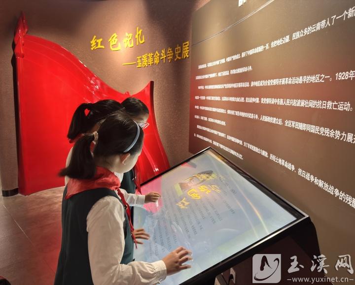 孩子们在红色文化展馆前驻足，了解玉溪的革命历史。